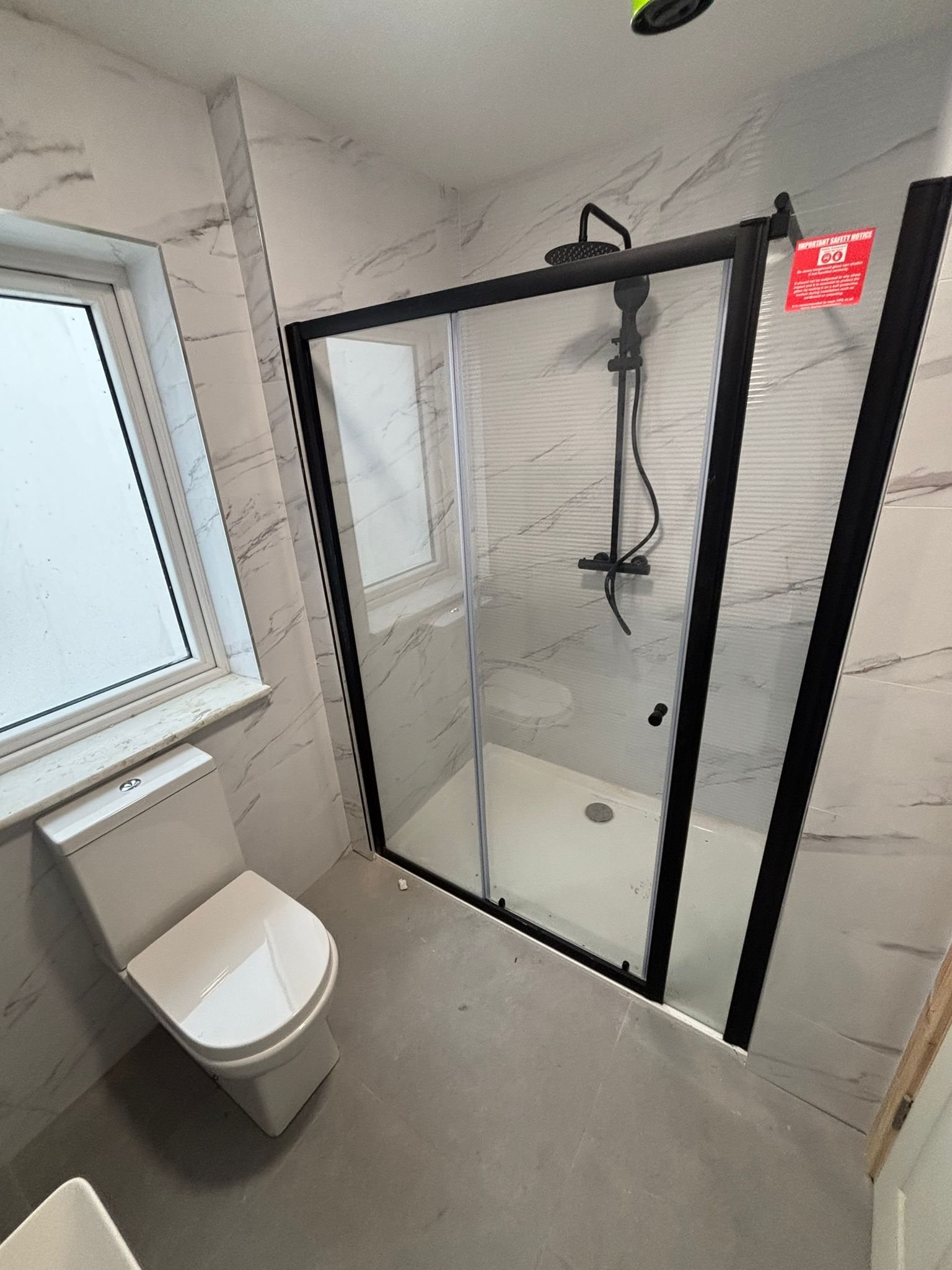 Marble bathroom with black-framed shower, Cork City