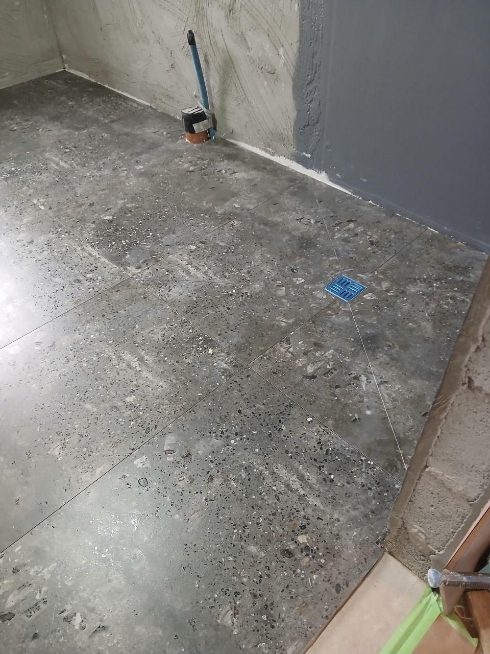 Terrazzo-style bathroom floor tiling around a drain in Cork