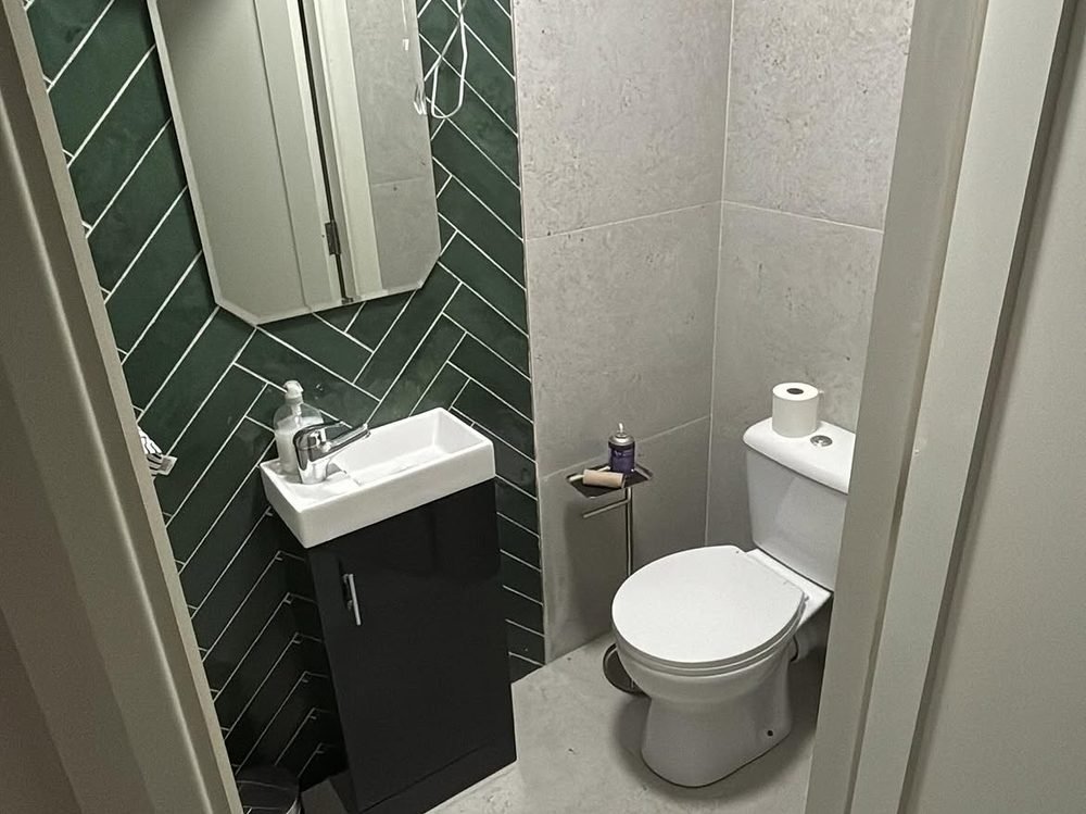 Finished cloakroom with green herringbone tiling by Serdiuk Plumbing in Cork