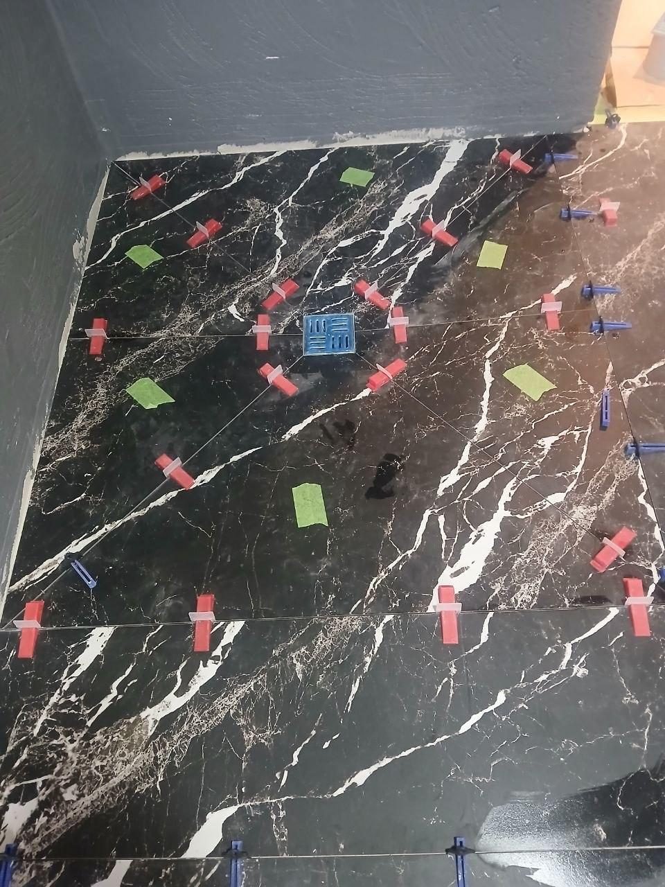 Black marble-effect floor tiling in progress in Cork