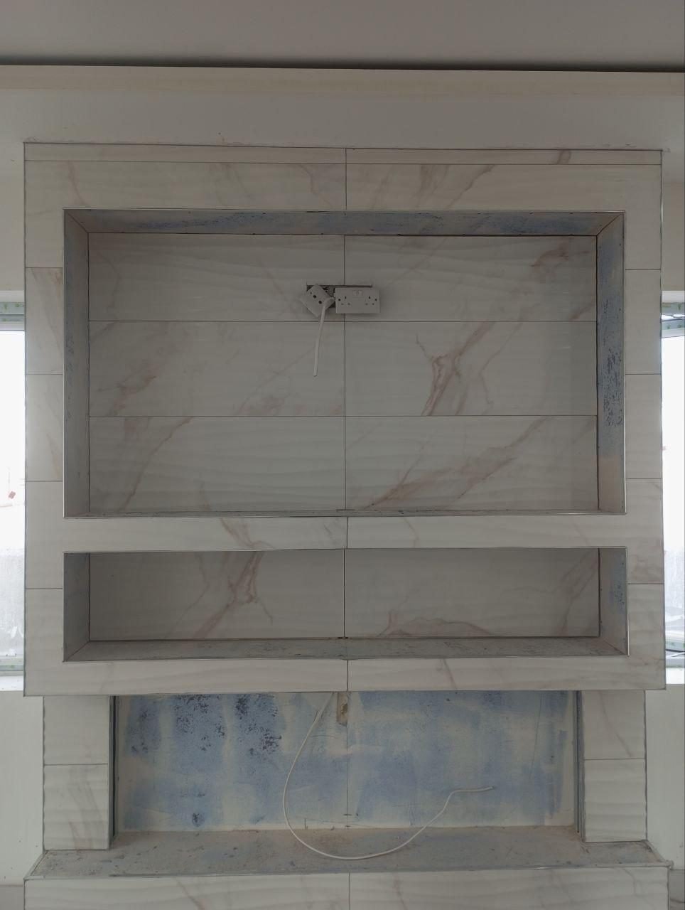 Tiled media wall with recessed niches in Cork